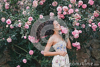 Young woman among roses in a garden