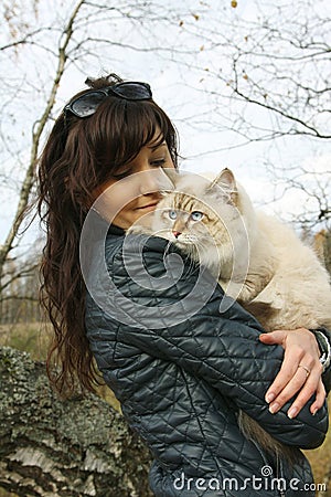 Young woman and siberian cat in a autumn forest