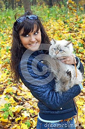 Young woman and siberian cat in a autumn season