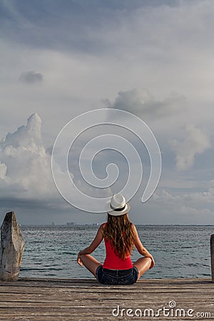 Young woman sitting with crossed legs and enjoying