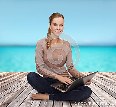 Young woman sitting on floor with laptop