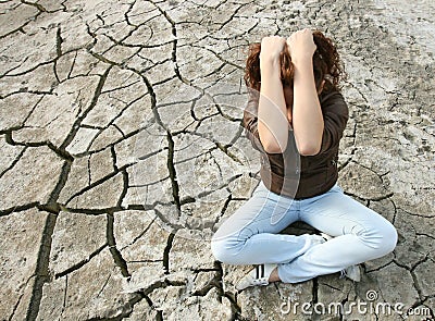 Young woman sitting in the middle of a desert.