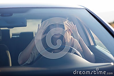 Young woman sitting scared in car.