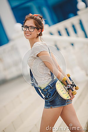 Young woman with a skateboard on the street of the city