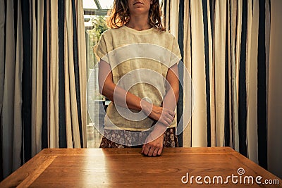 Young woman standing by curtains of french doors