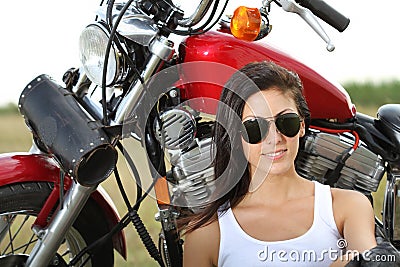 Young woman standing near a motorcycle