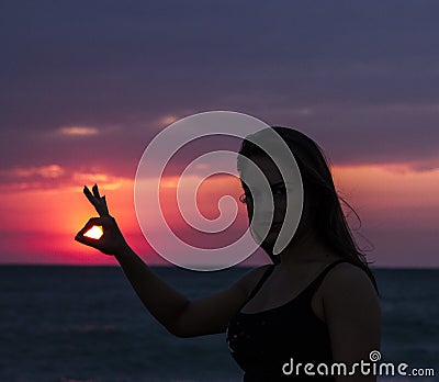 Young woman with the Sun in hand