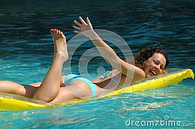 Young woman swimming on mattress