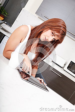 Young woman with a Tablet PC in the Kitchen