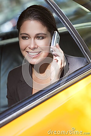 Young Woman Talking on Cell Phone in Yellow Taxi