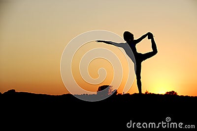 A young woman on top of a rock doing yoga