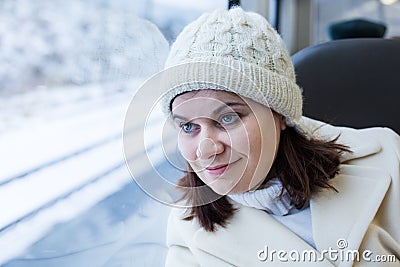 Young woman traveling by train and looking out the window