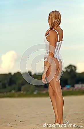 Young woman in underwear standing back on beach