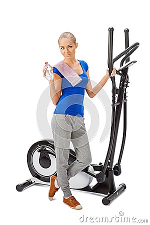 Young woman uses elliptical cross trainer.