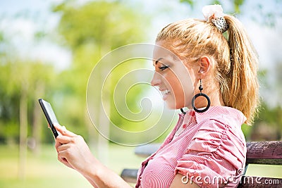 Young woman using digital tablet in the park