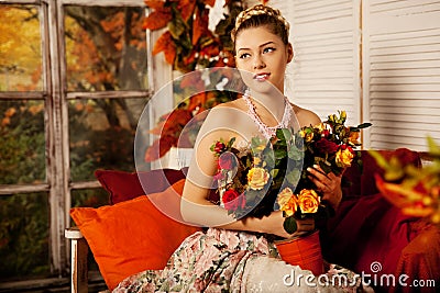 Young woman in vintage dress on autumn porch. Beauty girl in fa