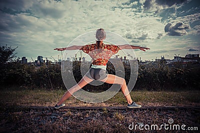 Young woman in a warrior pose outside