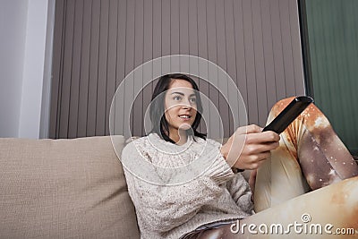 Young woman watching TV in living room