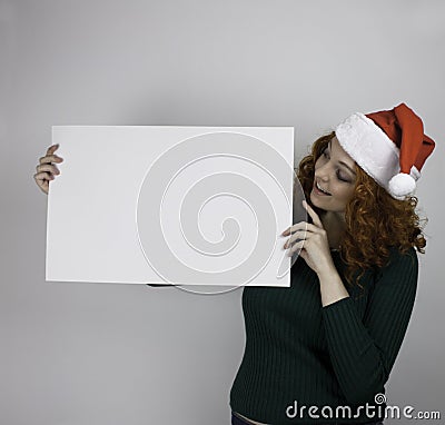 Young woman wearing Santa hat holding empty sign