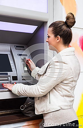 Young woman withdrawing money