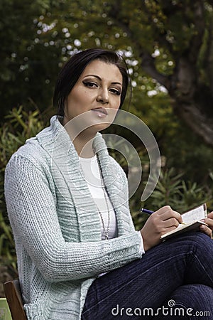 Young woman writing on a park