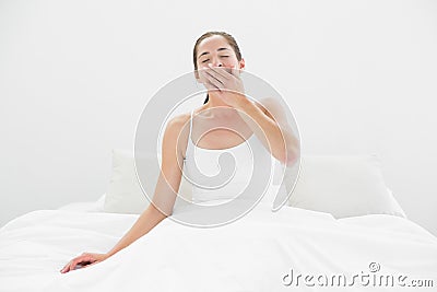 Young woman yawning in bed