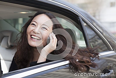 Young women in back seat of car using mobile phone.