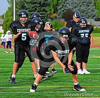 Youth American Football quarterback receives ball