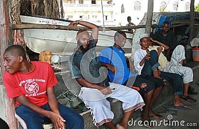 Zanzibar Stone Town, African Muslims black men rest in shade.
