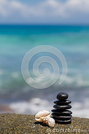 Zen stones jy on the sandy beach near the sea.