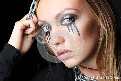 Zombie girl with black tears and cut throat hangs on chain