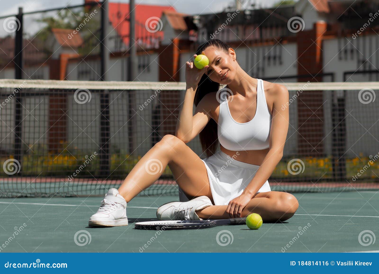 Alluring Adult Woman Sitting On Tennis Court In Sunlight Stock Photo