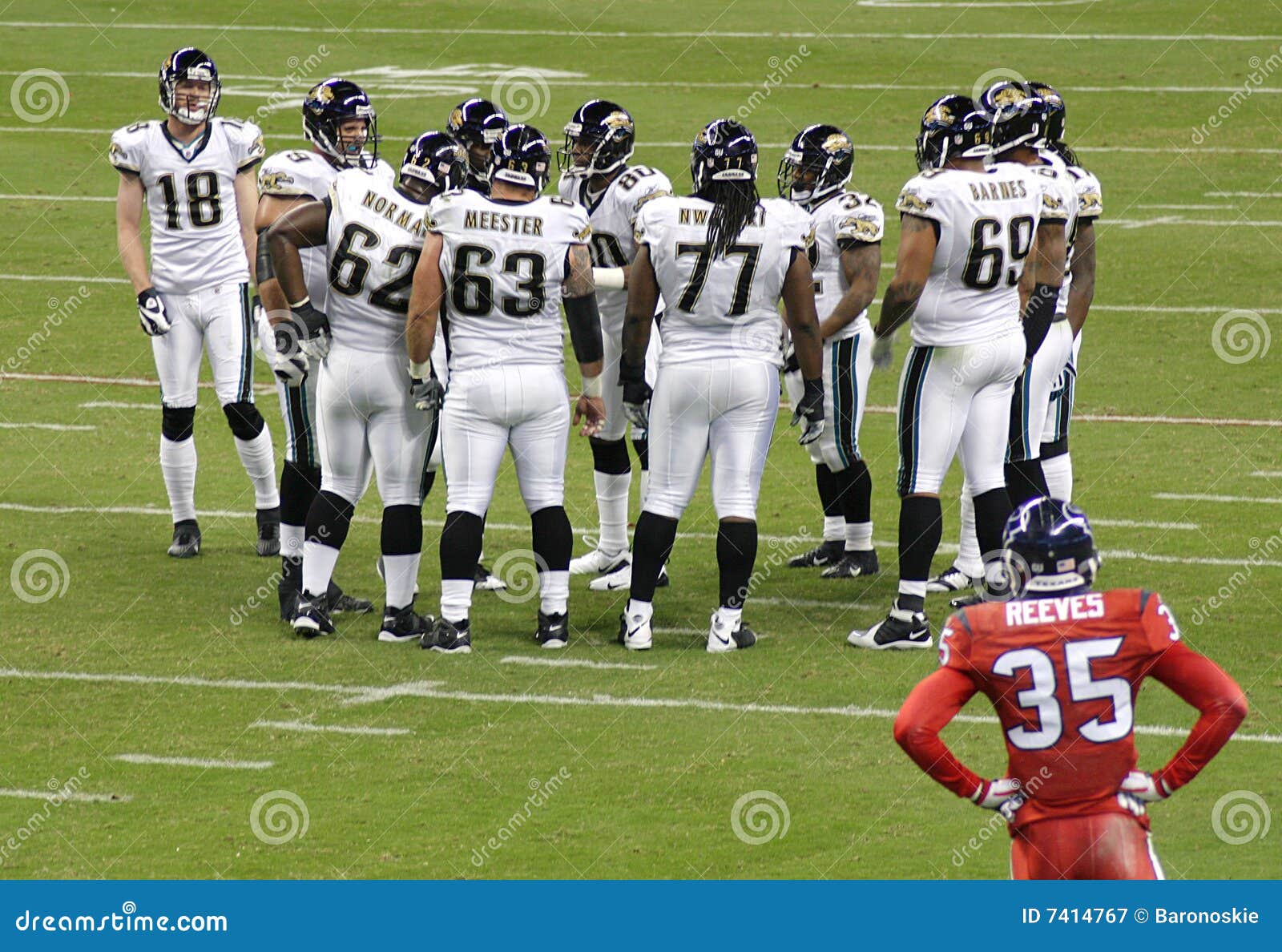 ... Football. One team huddles before a play while an opposing player