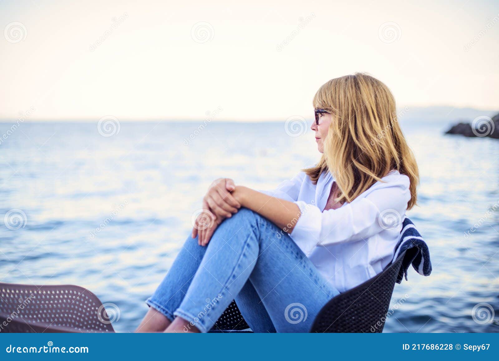 Attractive Mature Woman Wearing White Shirt And Blue Jeans While