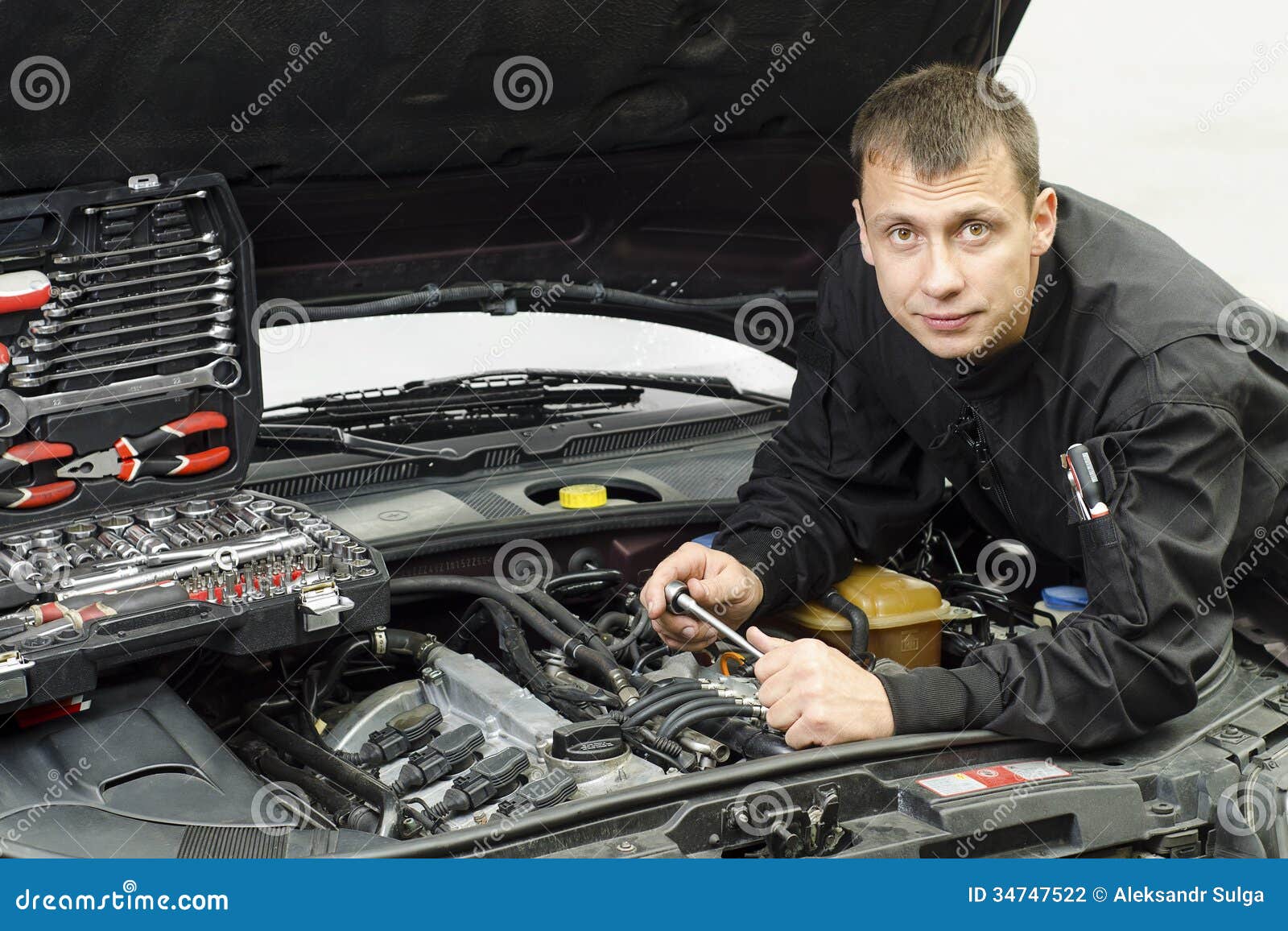 Auto mechanic working on a car engine repair.