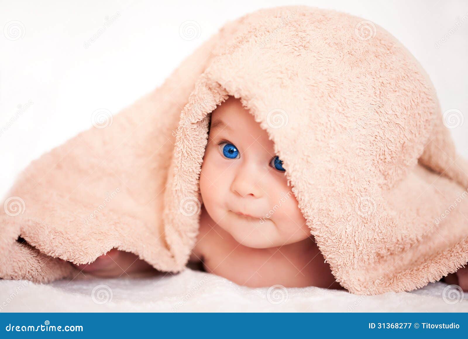 Baby girl is hiding under the beige terry towel - baby-girl-hiding-under-beige-terry-towel-blanket-31368277