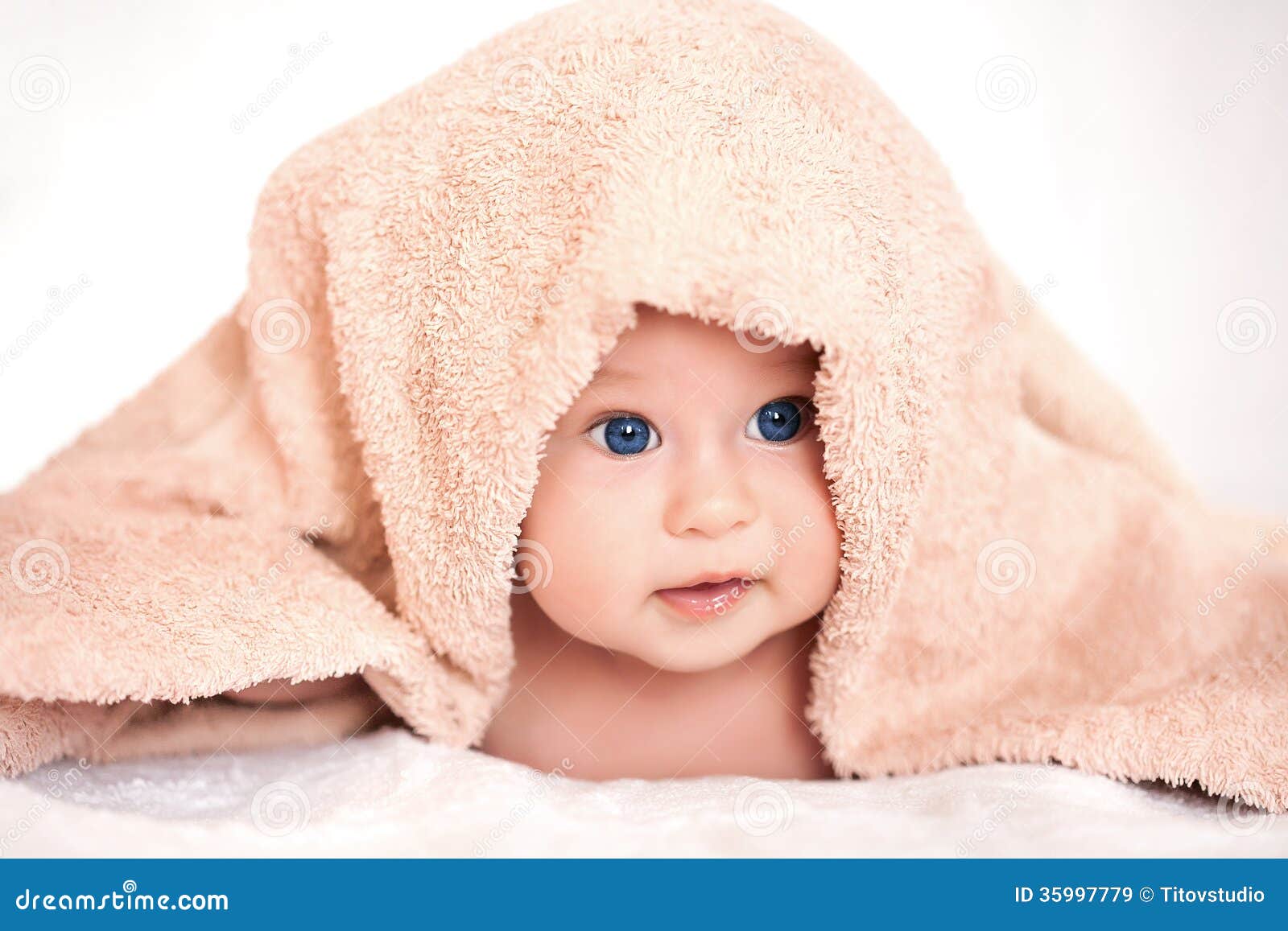 Baby girl is hiding under the beige terry towel Royalty Free Stock Images - baby-girl-hiding-under-beige-terry-towel-blanket-35997779