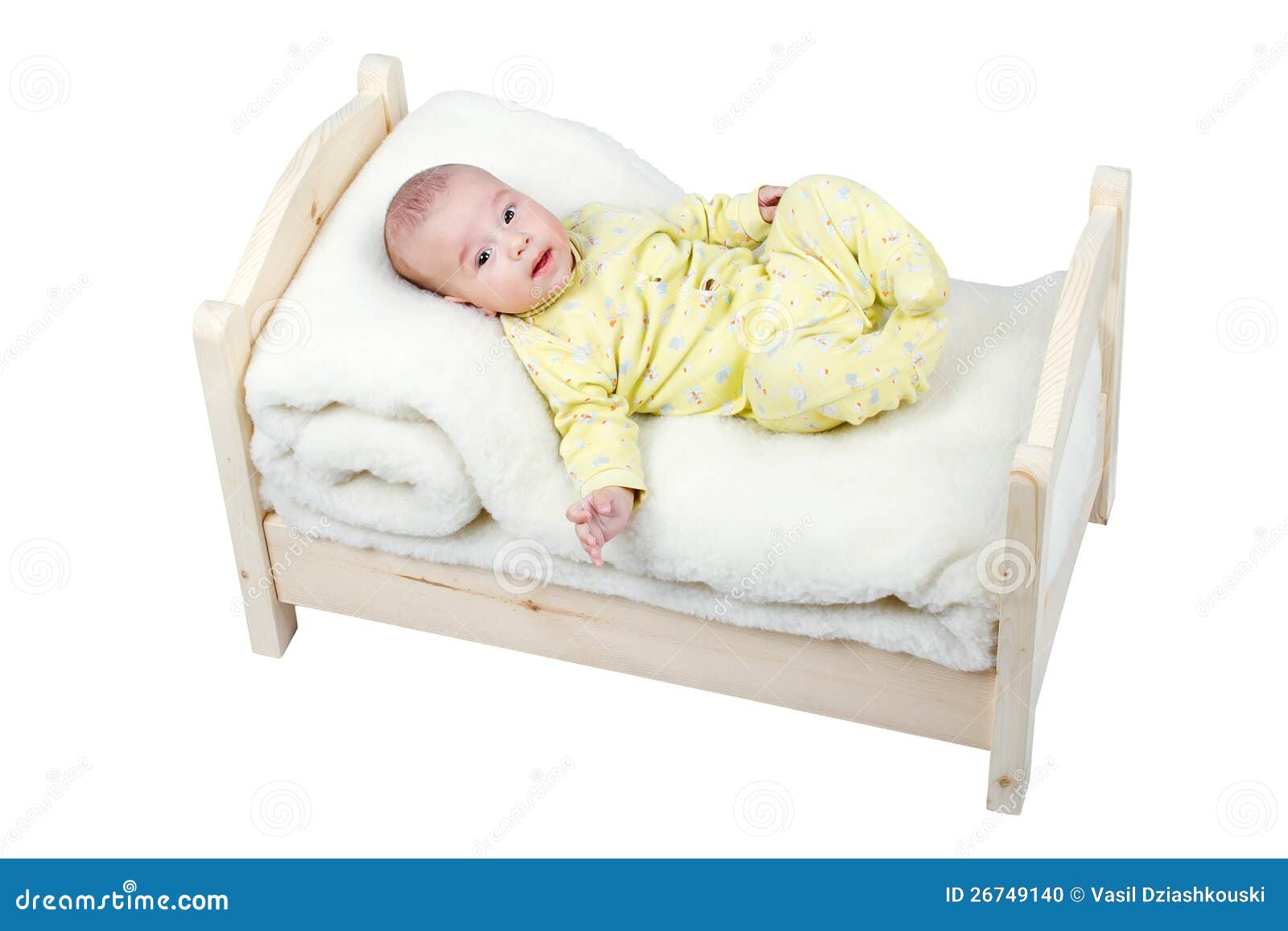 Cheerful baby lies in a wooden crib.