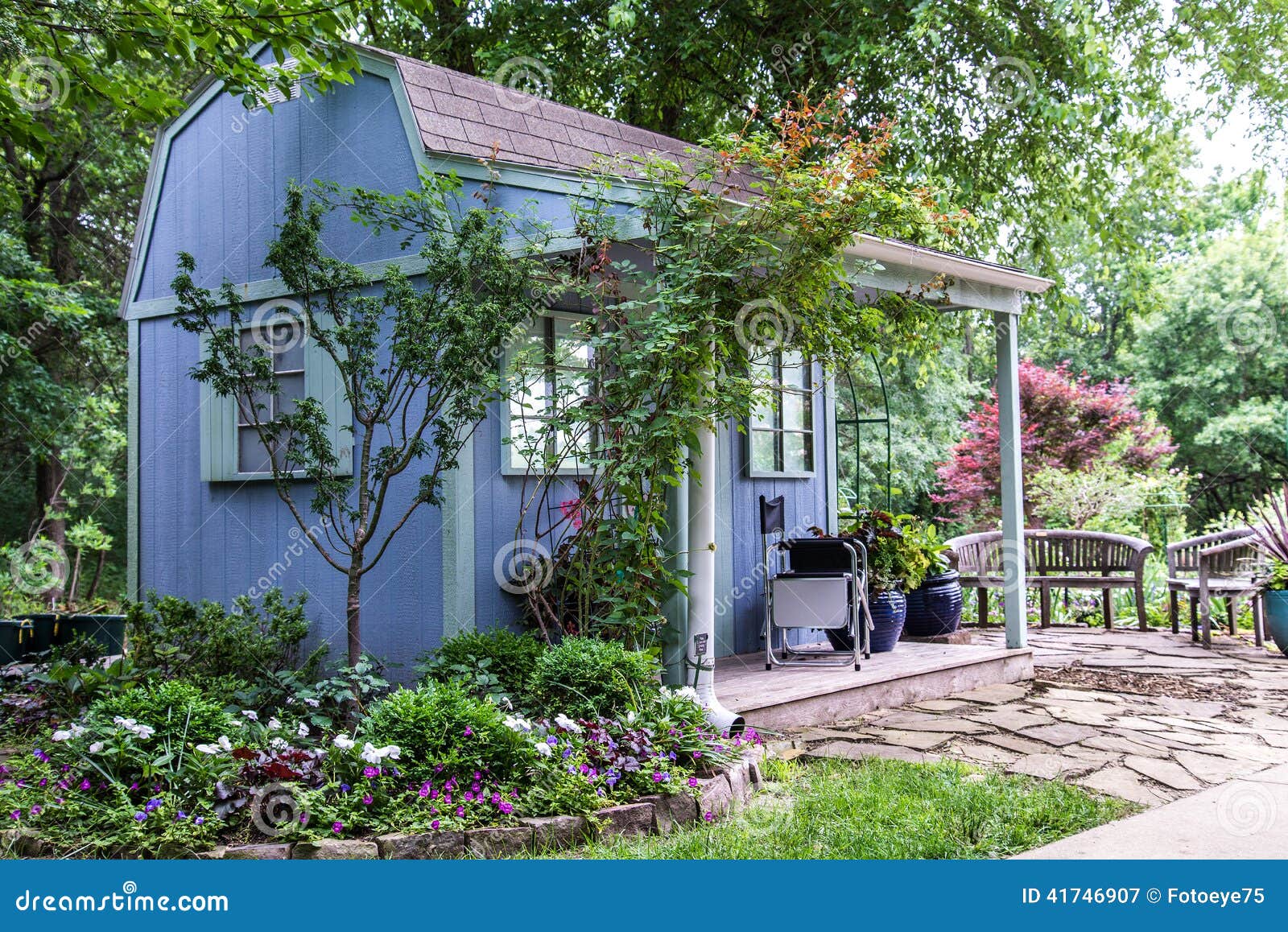 Small building / backyard shed surrounded by beautiful landscaping 