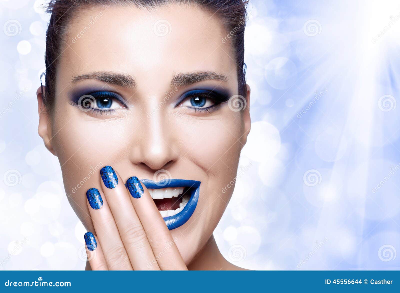 Beautiful Girl in Blue with Hand on Her Face. Nail Art and Makeu - beautiful-girl-blue-hand-her-face-nail-art-makeu-trendy-winter-makeup-young-woman-laughing-covering-half-mouth-45556644