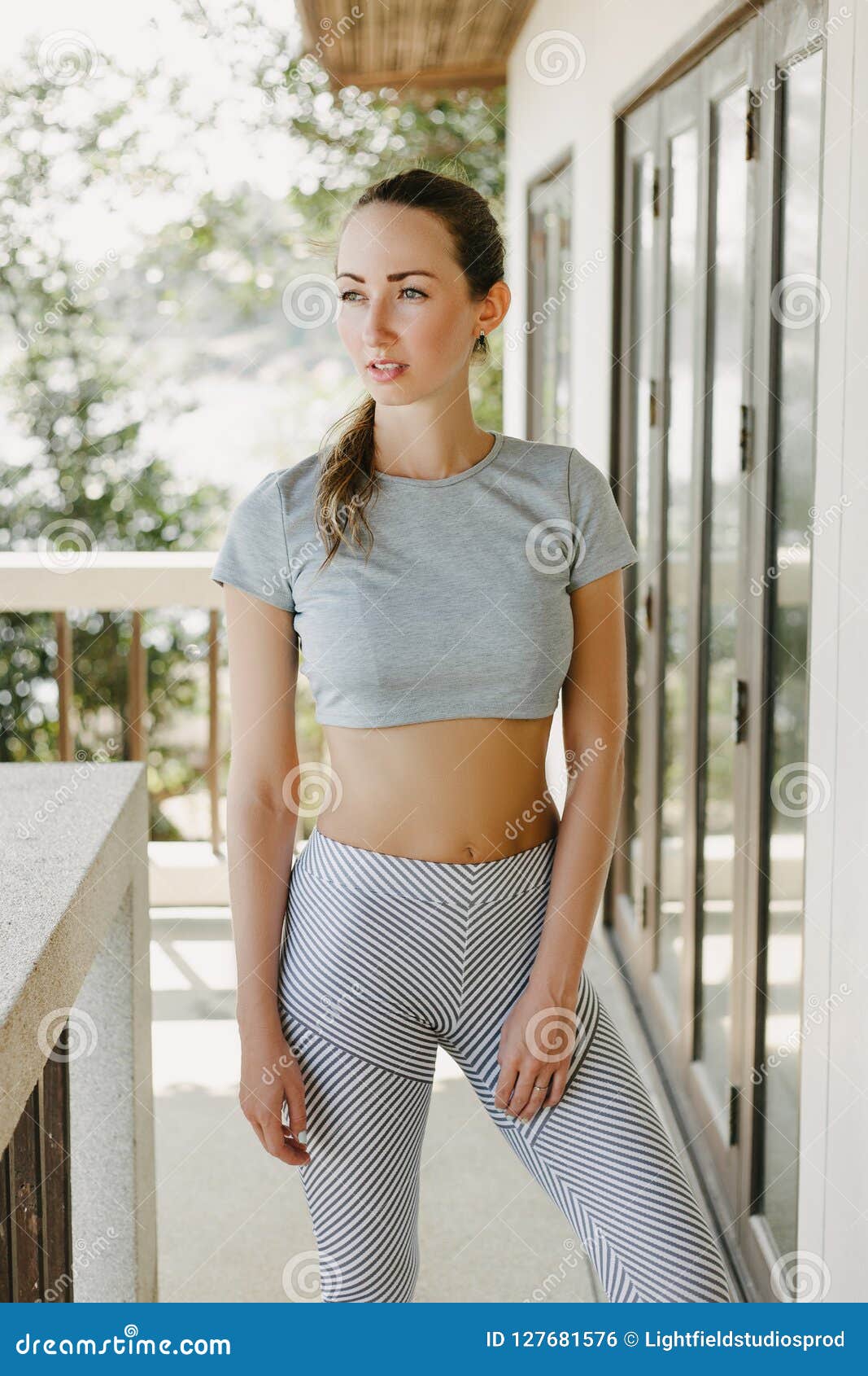 beautiful-slim-woman-sportswear-standing-porch-127681576.jpg