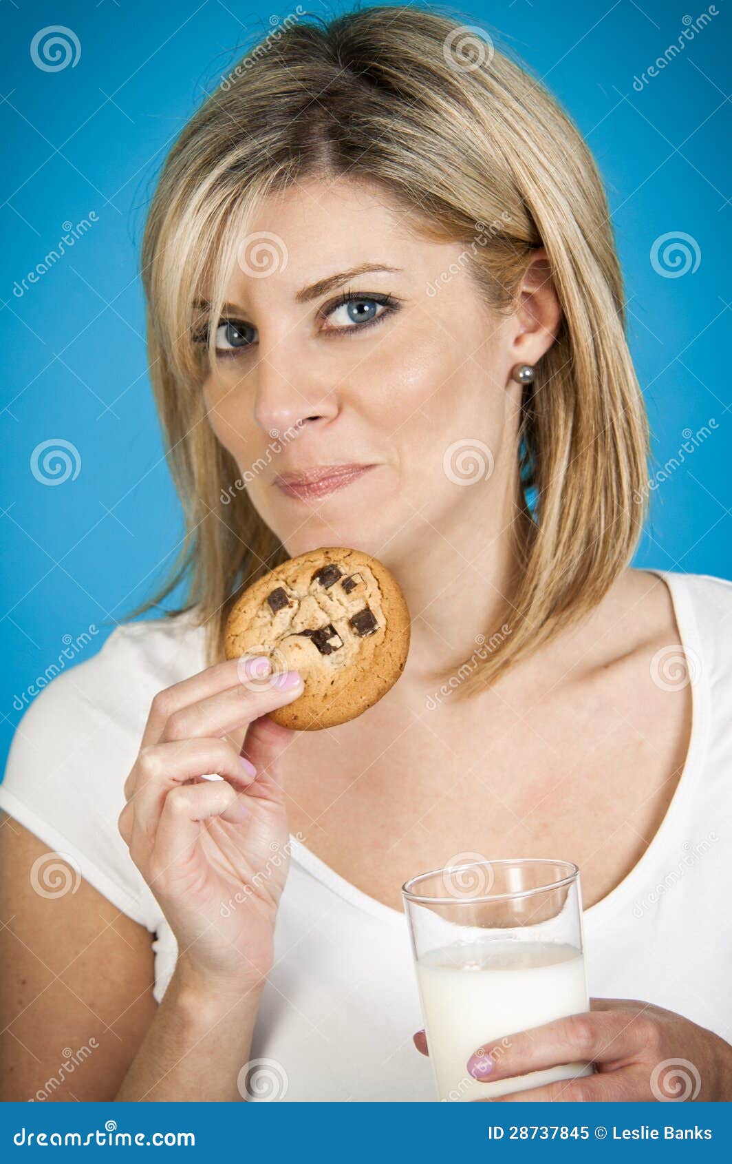 Beautiful woman enjoying cookies and milk - beautiful-woman-enjoying-cookies-milk-28737845