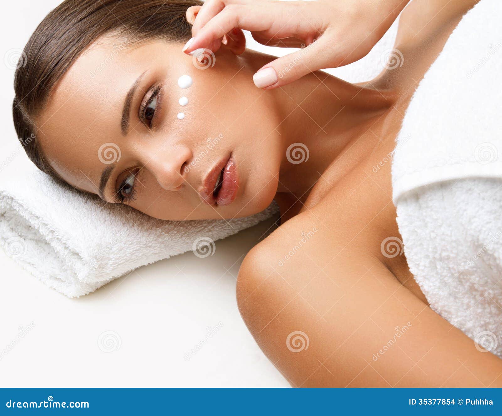 Beautiful woman getting spa treatment. cosmetic cream on a cheek stock images - image: 35377854.