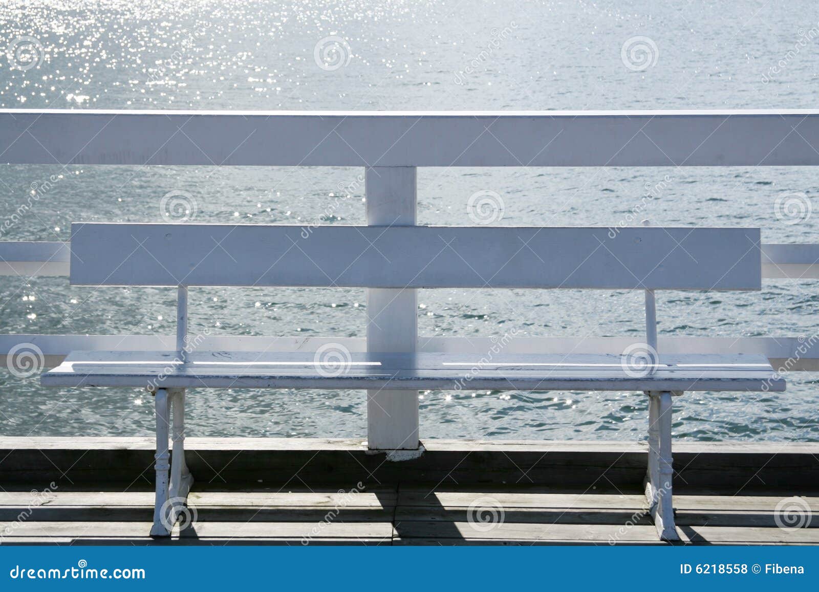 white wooden bench on a pier at the seaside.