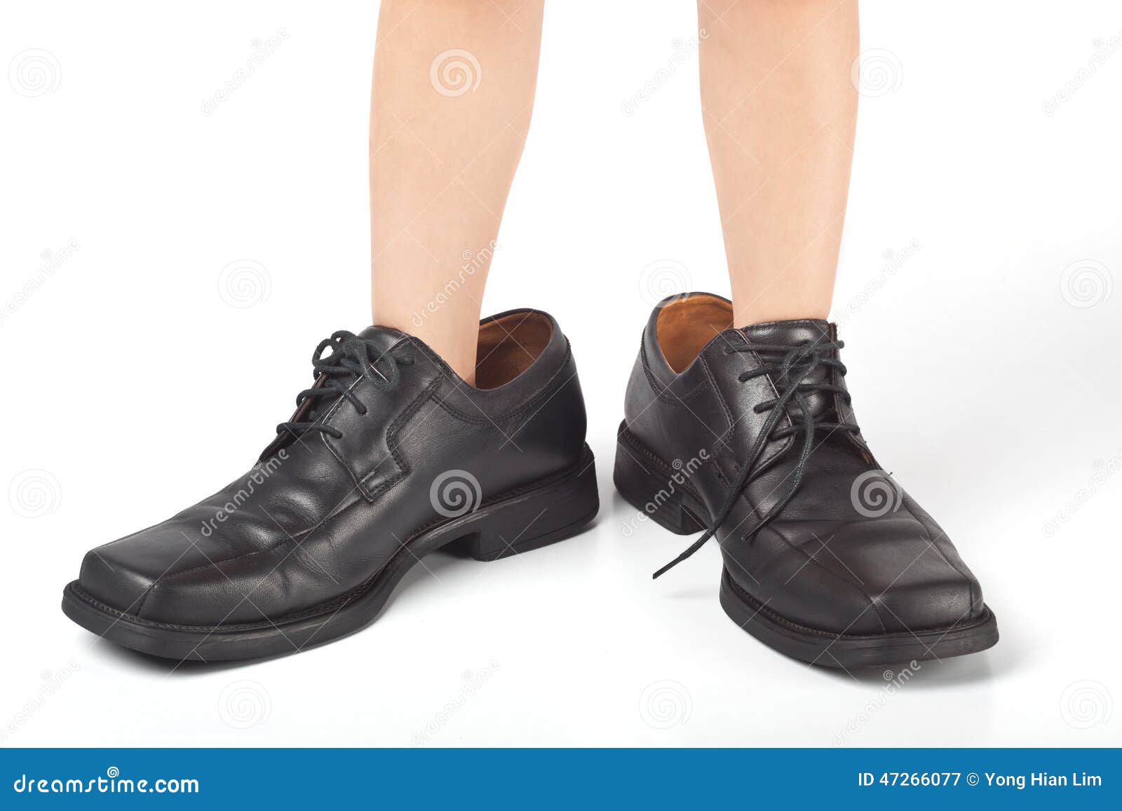 Little kid wearing adult's shoes that are too big.