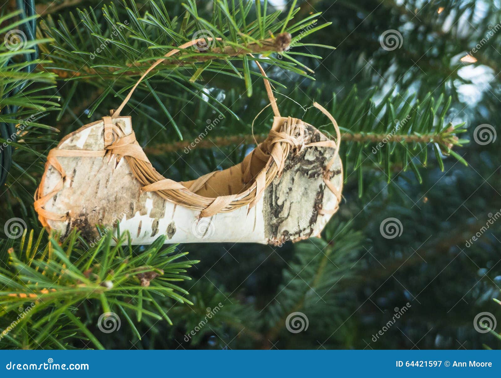 Birch bark canoe ornament hanging on a Christmas holiday tree.
