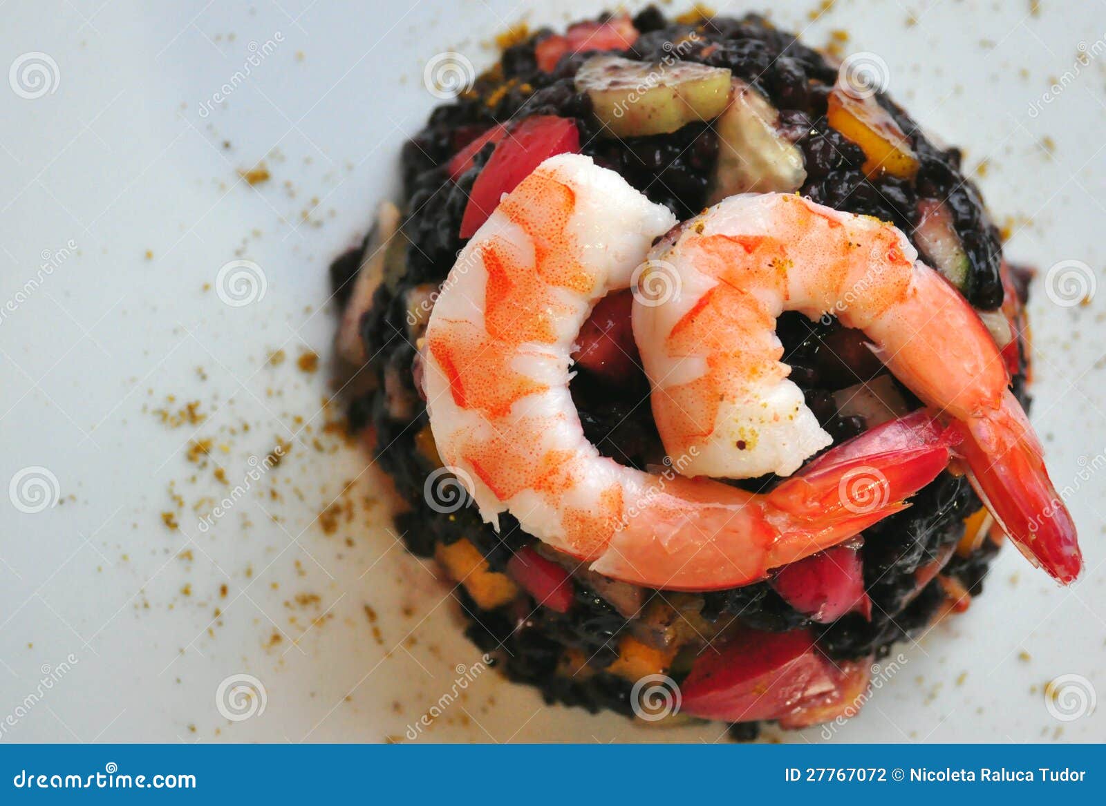 Black rice salad with shrimps on a white background. italian chef food ...