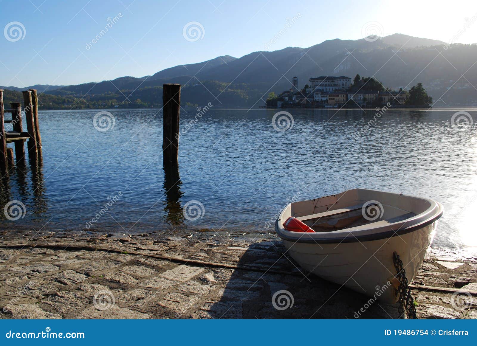 Boat on the dock at Orta lake, St. Giulio island in background 