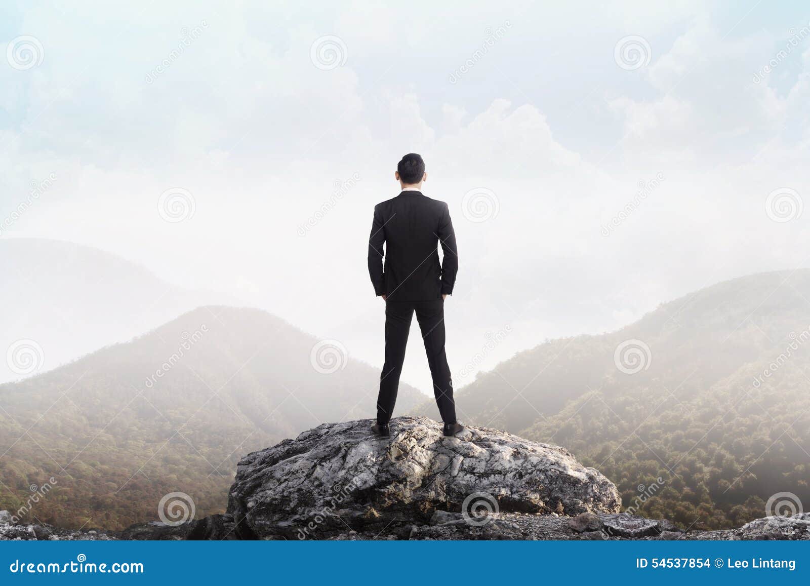 Man Standing On Mountain Top | business man standing on the top of the mountain looking Man Standing On Mountain Top | business man standing on the top of the mountain looking