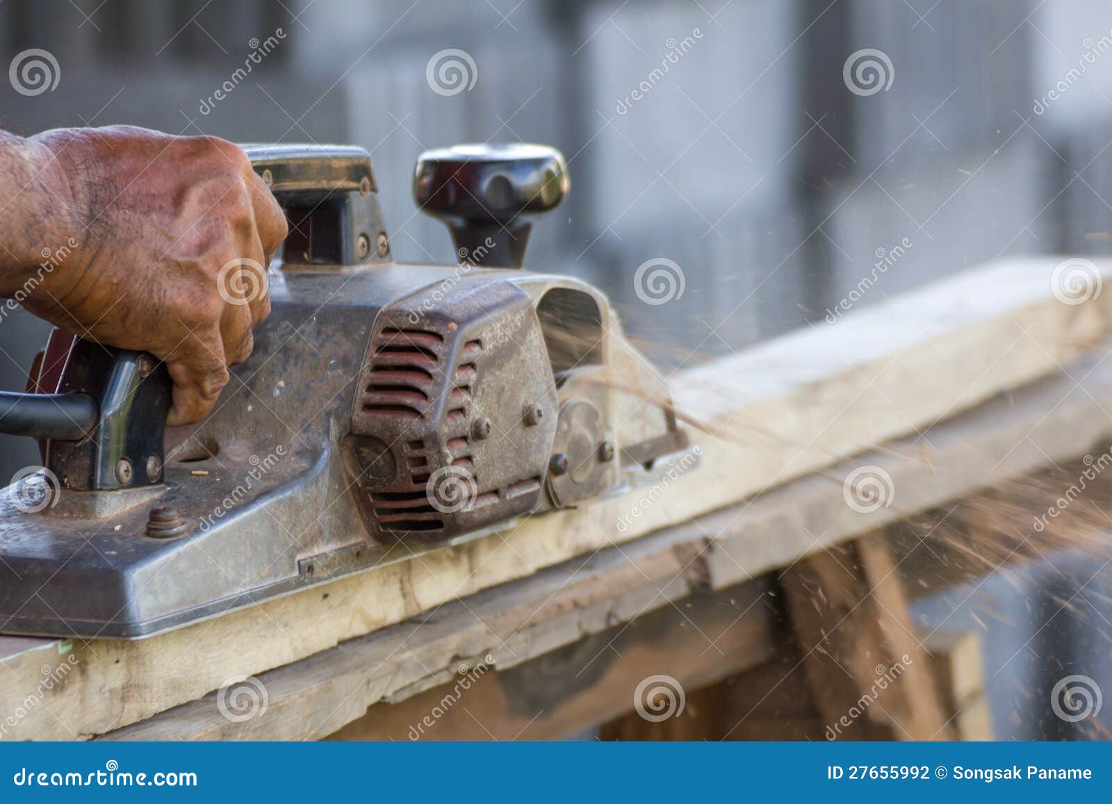 Carpenter working with electric planer in his workshop, close up on 